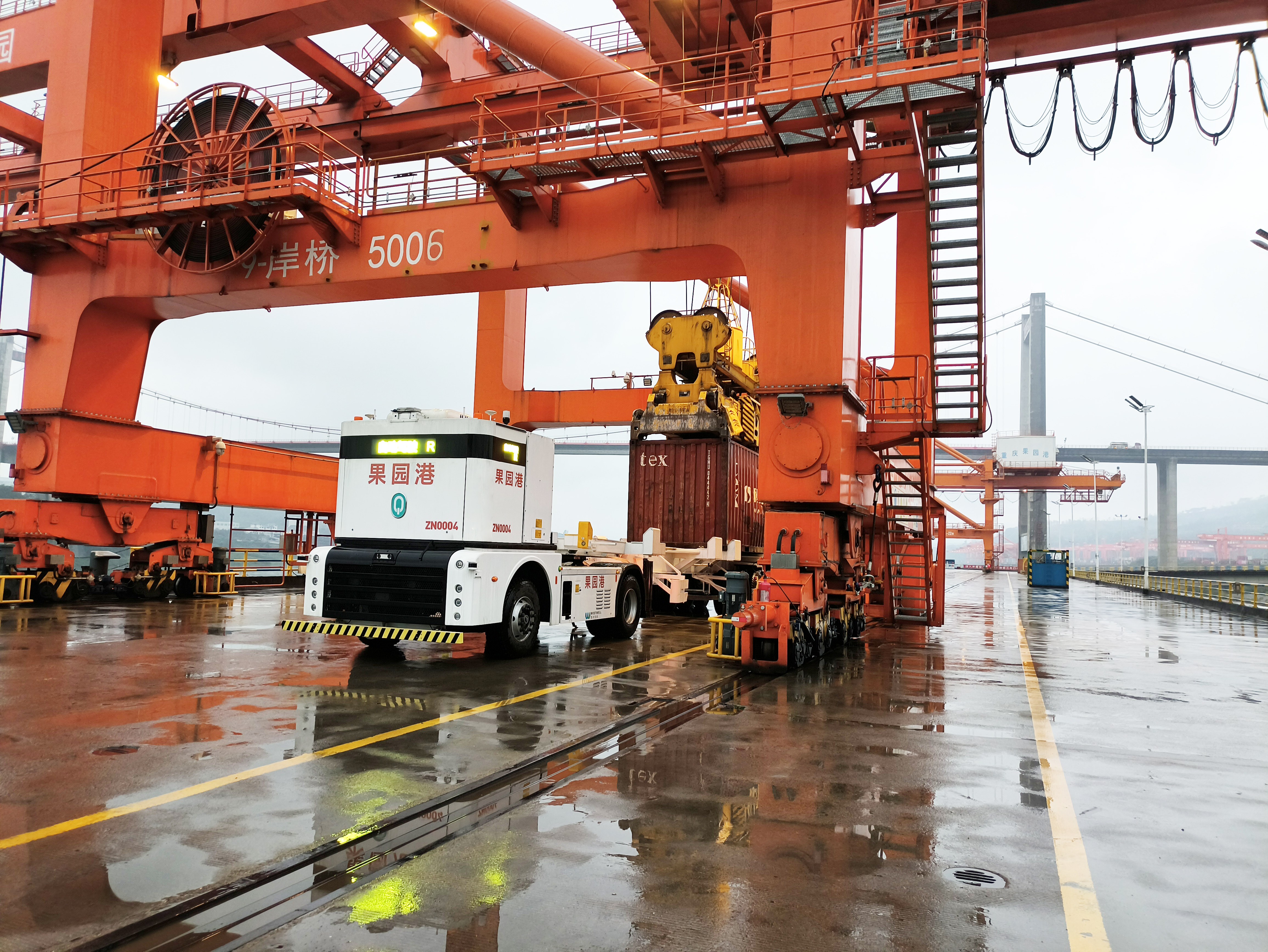 西井科技Q-Truck无人驾驶集卡在重庆果园港码头岸桥下进行集装箱装卸运输作业。