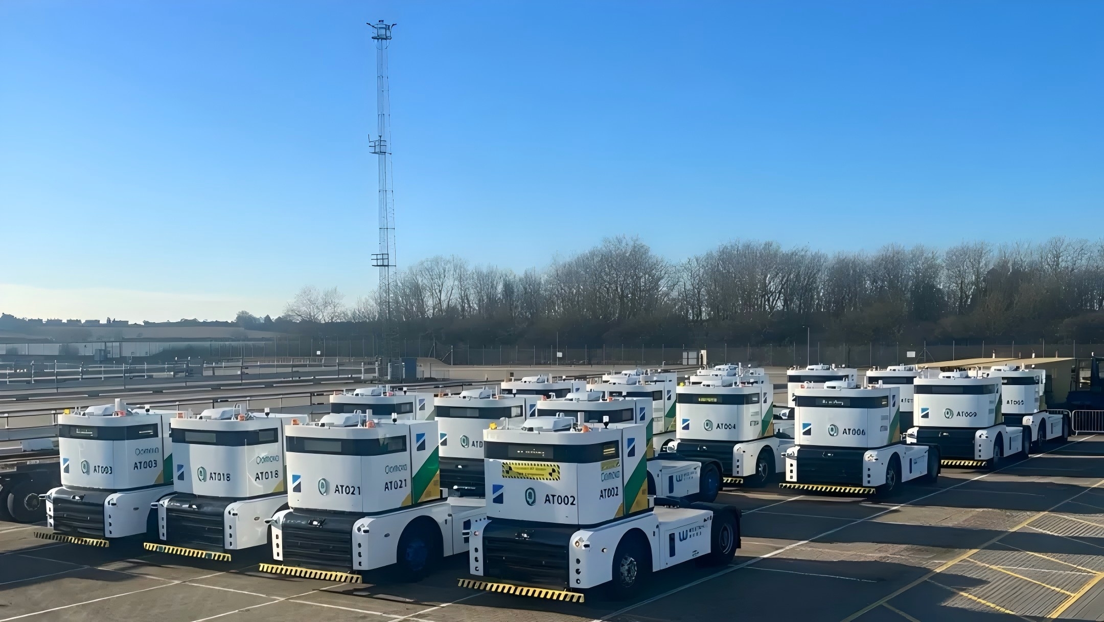 西井科技无人驾驶新能源Q-Truck车队正在港口水平运输通道中协同行进，展现了智慧港口物流场景下，规模化自动驾驶车队如何实现高效、安全的集装箱转运作业。