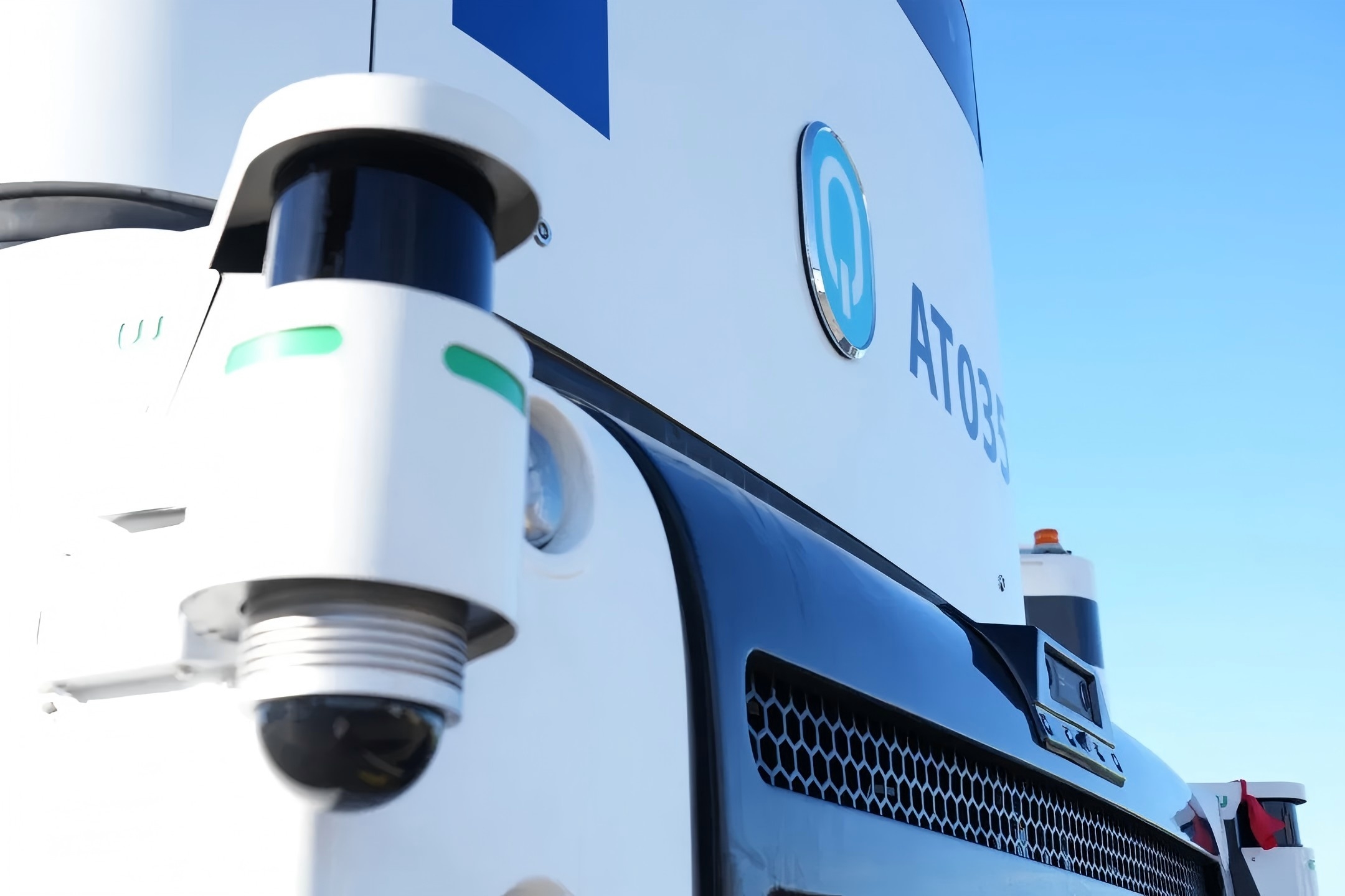 西井科技Q-Truck前脸特写，清晰展示其搭载的智能感知硬件，包括双目摄像头与激光雷达，体现了无人驾驶车辆在智慧港口复杂环境中实现高精度环境感知与安全冗余的核心技术配置。